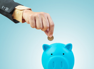 person dropping a coin in the piggy bank